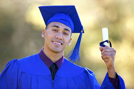 Graduate in cap and gown holding a diploma