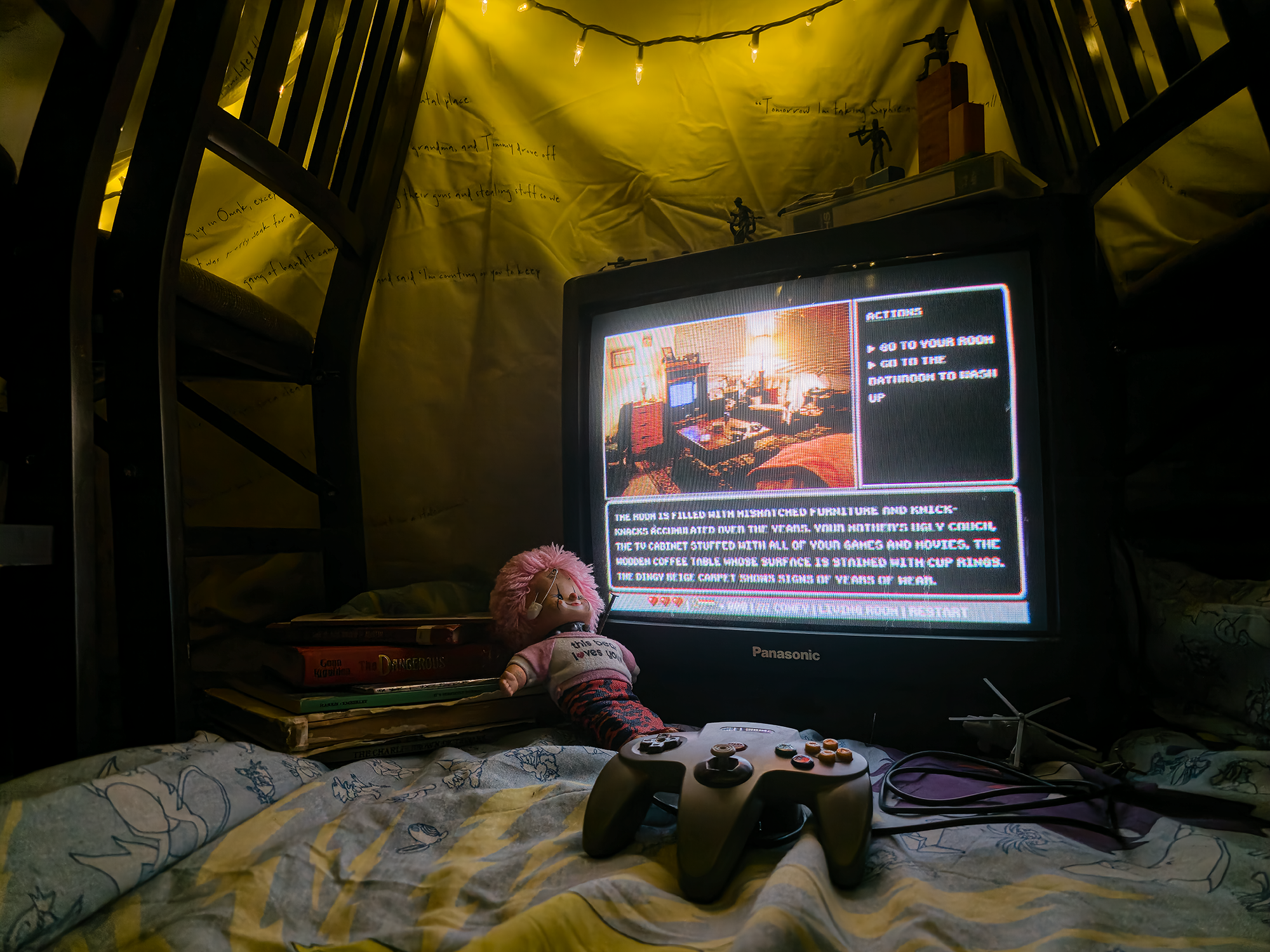 TV displaying video game with vintage books and doll. 