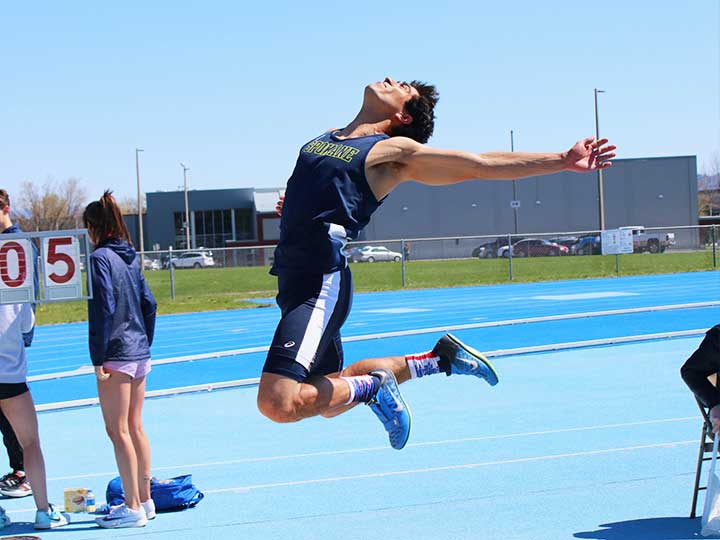 Men's track and field long jumper in mid air