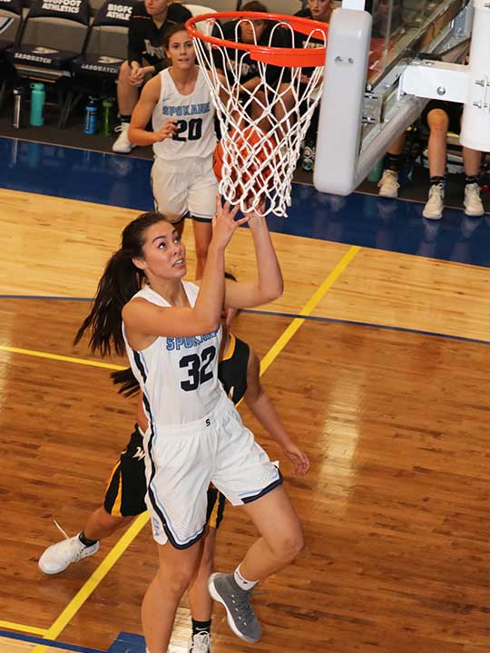 Women's basketball player going for the layup shot