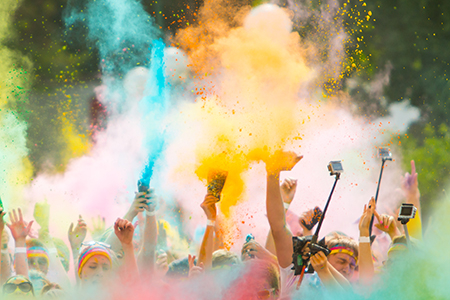 A crowd throwing color powder in the air at a color run