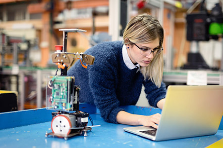A student testing her engineering project on a laptop